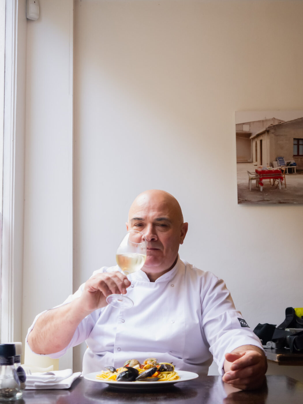 Portret foto van Chef-Kok Gero. Hij zit een bord pasta te eten in zijn eigen restaurant in Amsterdam - ©GittaPolak